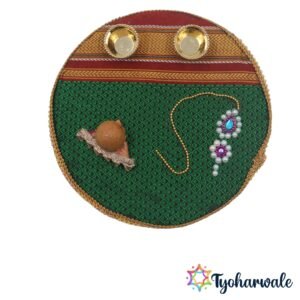 Traditional haldi kumkum gifting set with nath and coconut decor on green and red striped fabric