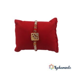 Gold-tone designer beaded Rakhi with red thread and pearl beads