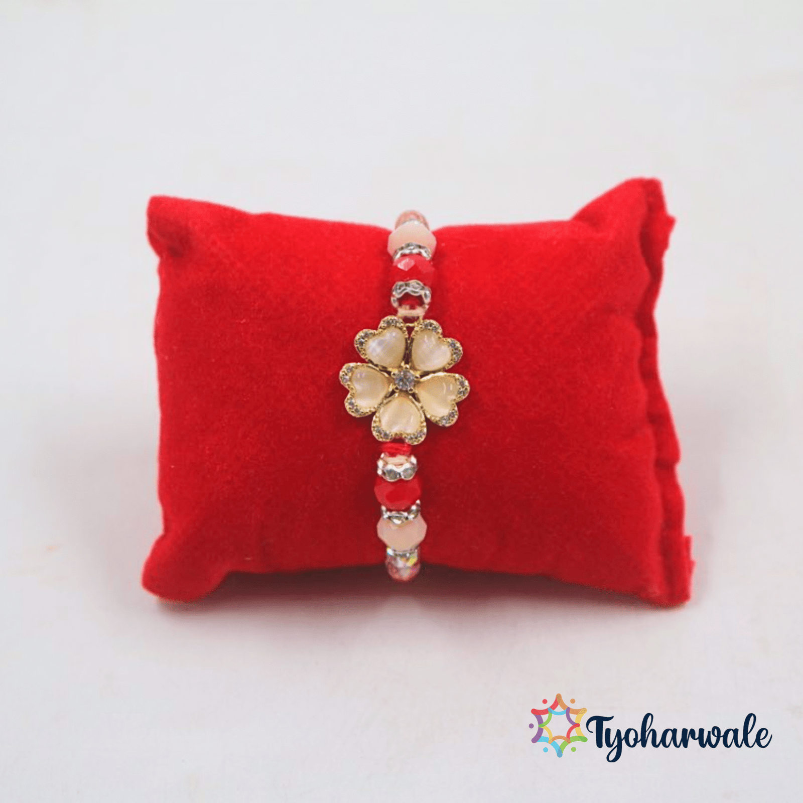 Elegant flower charm beaded Rakhi with soft pink petals, red and pink beads