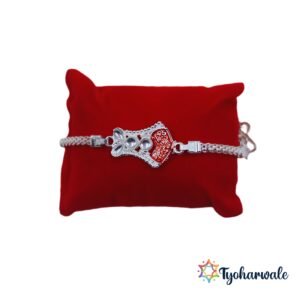 Silver-toned designer Rakhi with red side detailing and premium stone work